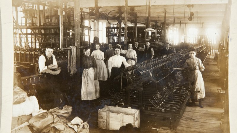 Industrial factory floor with textile machines and workers during the height of the Industrial Revolution circa 1880